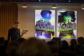 Andreas Schlüter im Studio des Theaters. An der Wand Projektionen der Buchcover.